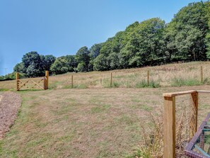 A fenced field with a wooden gate, surrounded by trees and a clear sky. - 2 bedroom accommodation in Whitwell (Whitwell)