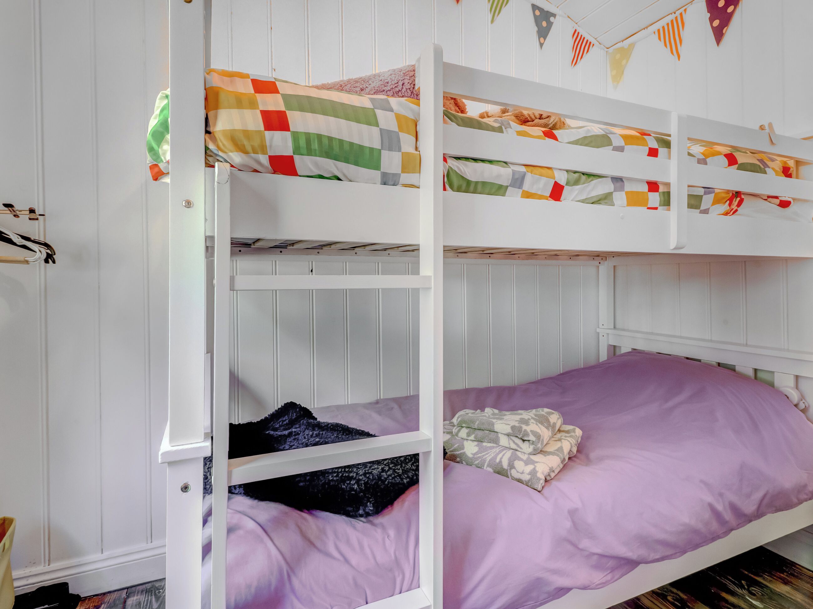 Un lit superposé avec un matelas violet et une couverture matelassée.