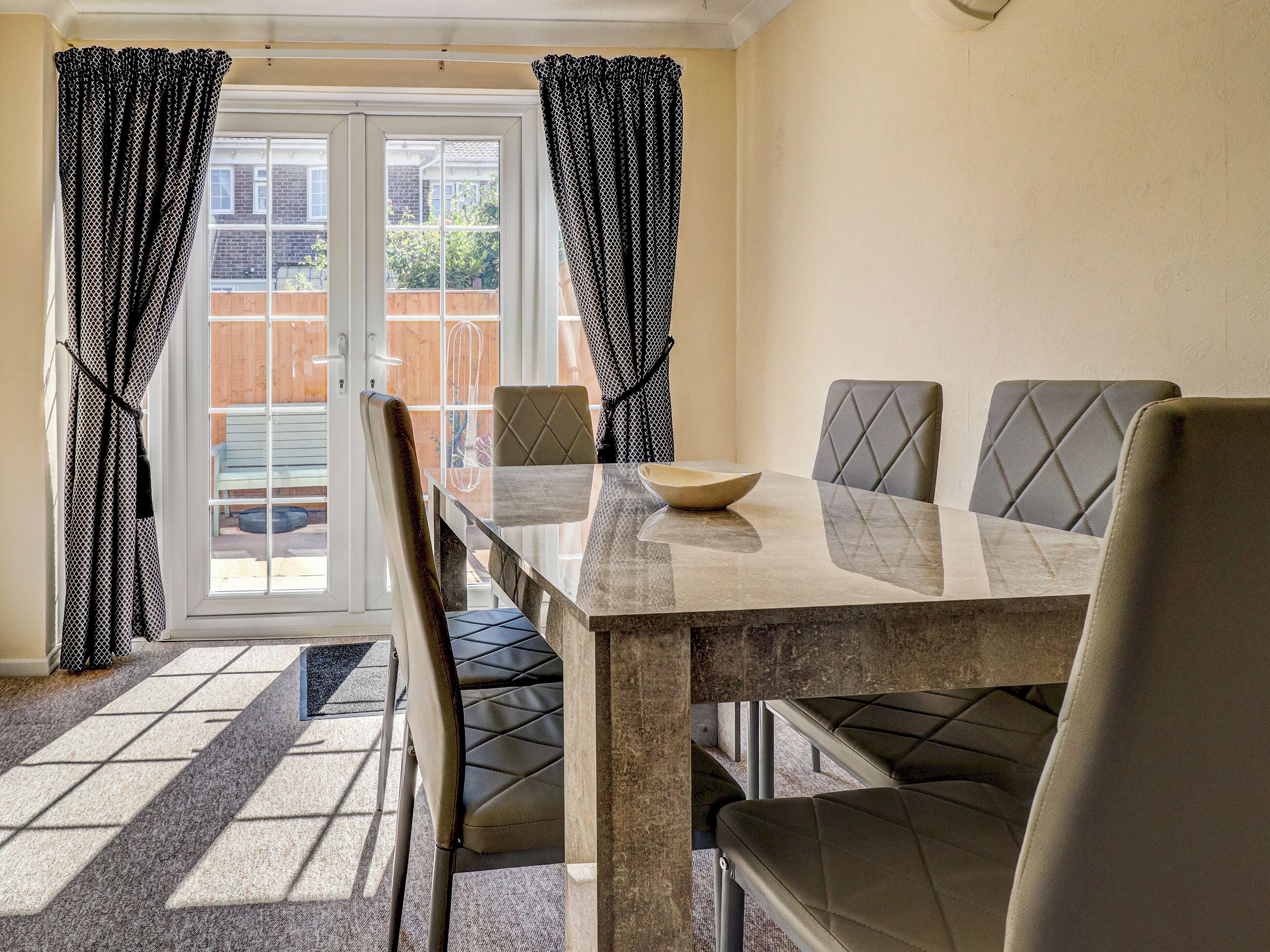 A dining area with a table, chairs, and a bowl.