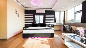 Een moderne slaapkamer met een bed, nachtkastjes, een bureau en een raam.
