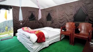 A tent with a bed, a chair, and a view of a mountainous landscape. - Prince Campsite (Chail)