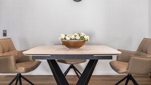 Comedor con una mesa, sillas, un reloj y un arreglo floral.