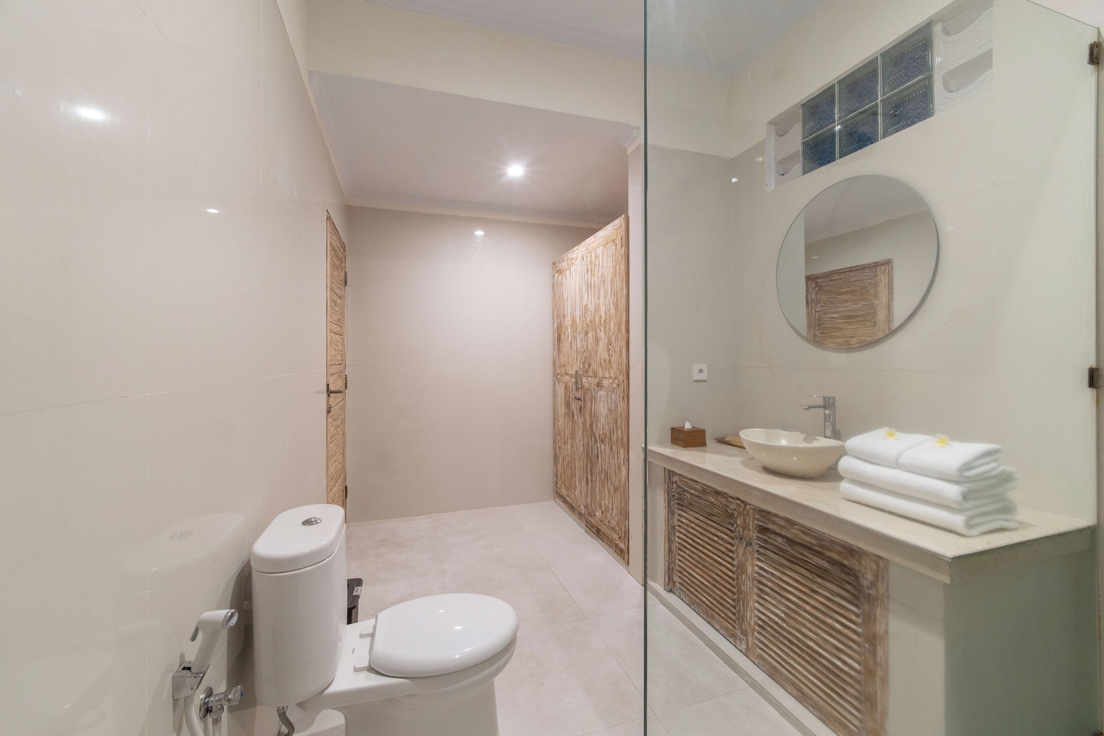 A modern bathroom with a toilet, a sink, and a mirror.