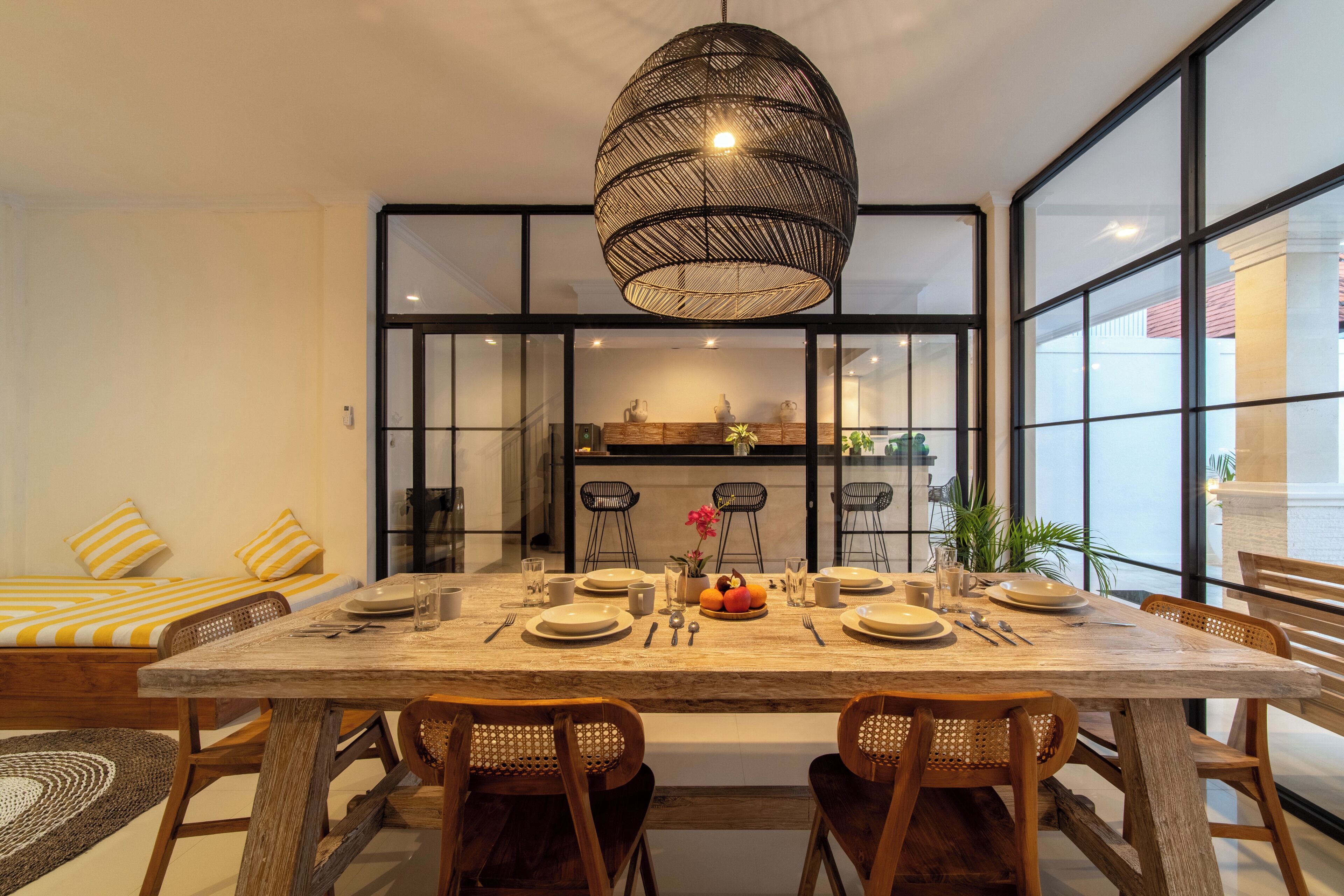 Un espace repas comprenant une grande table, des chaises et un luminaire suspendu.