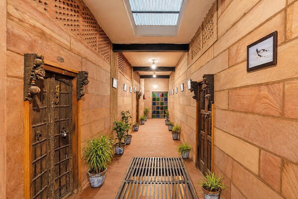 A hallway with ornate doors, potted plants, and a skylight. - Collection O Blue City Jodhpur Formerly (Jodhpur)