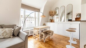 Ein gemütliches Wohnzimmer mit einer Couch, einem Holztisch und einem Hund.