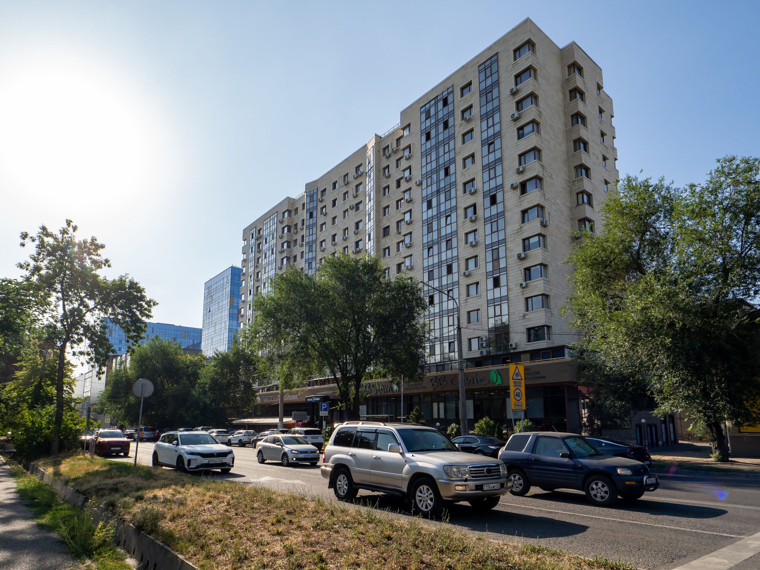 A multi-story building with a parking lot in front.