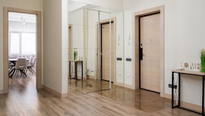 Ein modernes Interieur mit Holzboden, einer Glastrennwand und einer Tür mit Griff.