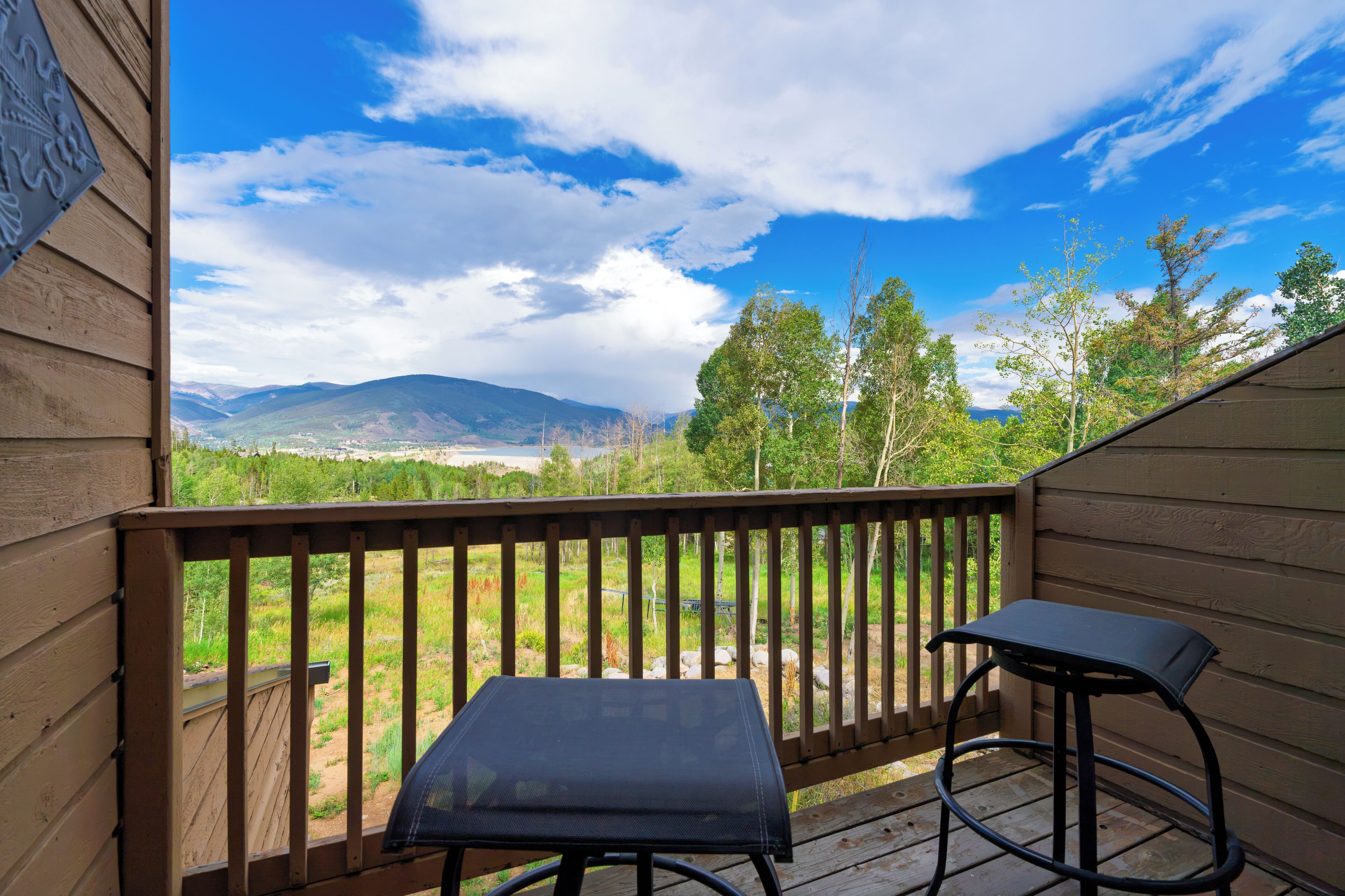 A wooden deck with a view of mountains and trees.