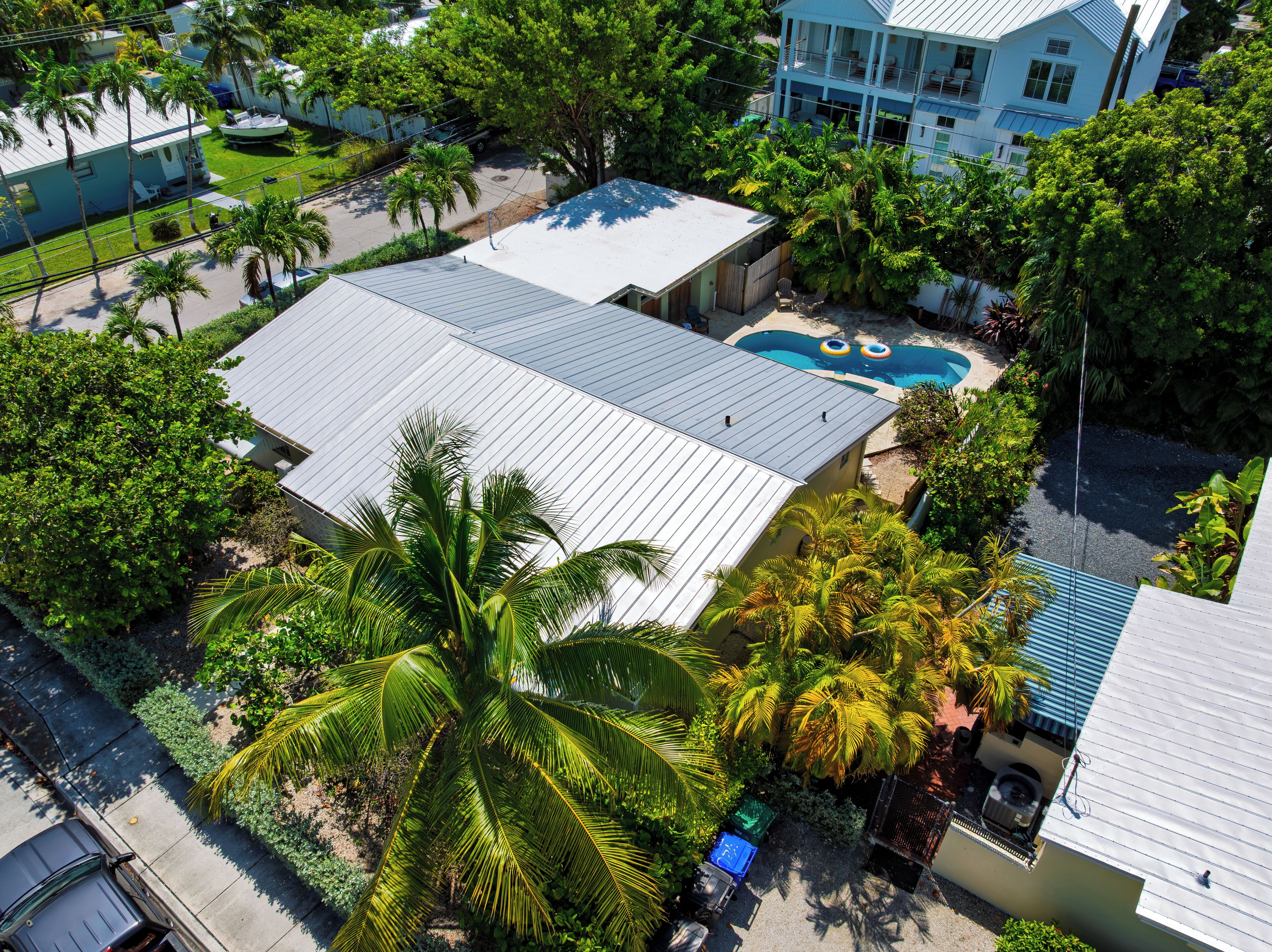 Zona residencial con piscina, varias casas y abundante vegetación.