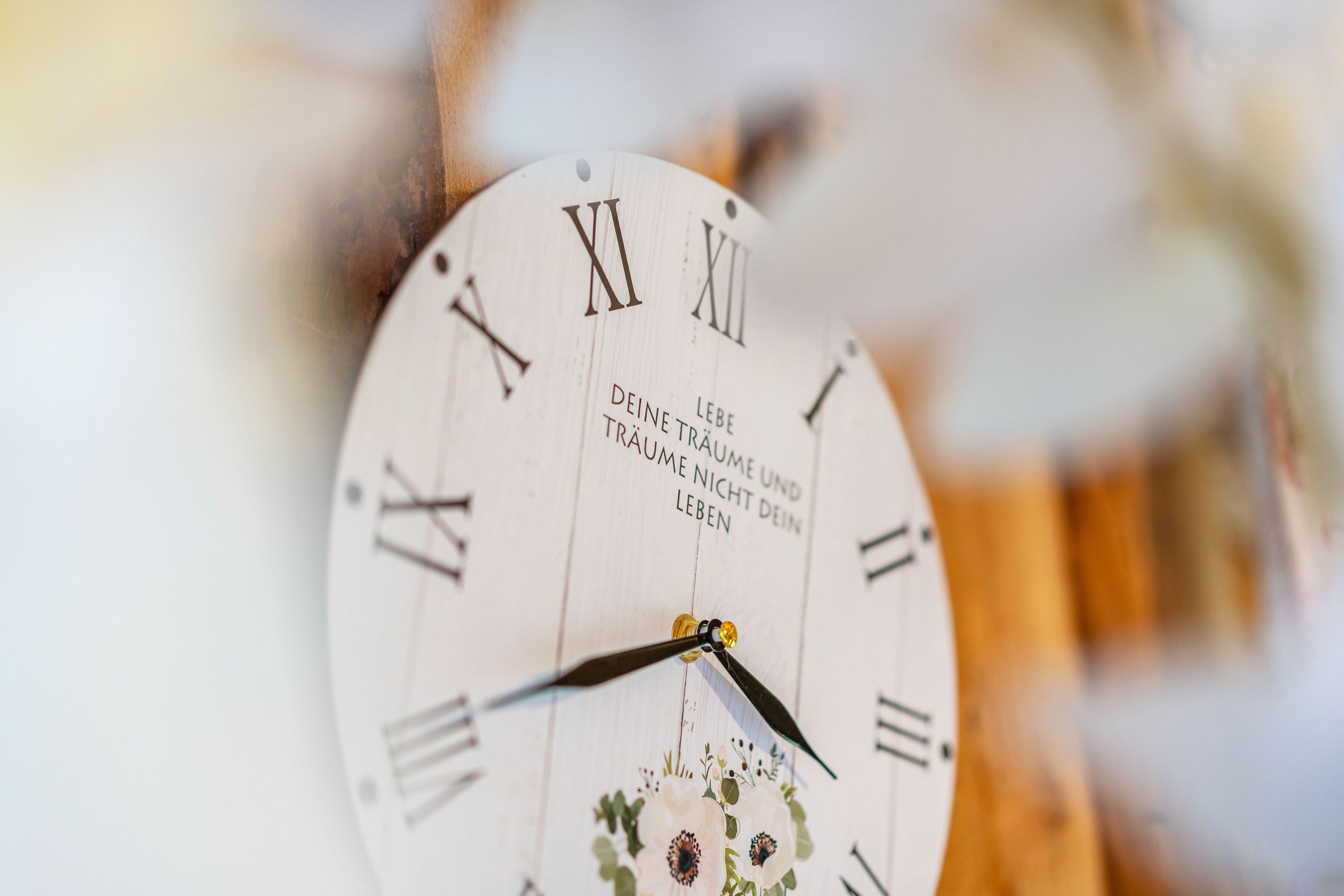 Eine Uhr mit römischen Ziffern und deutschem Text.