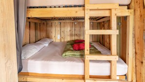 Ein Etagenbett mit einer Leiter, zwei Kissen und einer Decke.