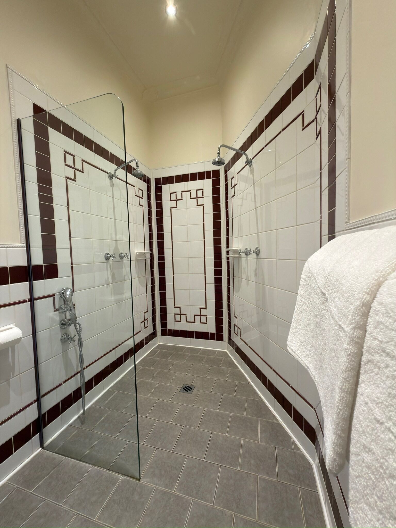 Un bagno moderno con cabina doccia in vetro, pareti piastrellate e soffione.