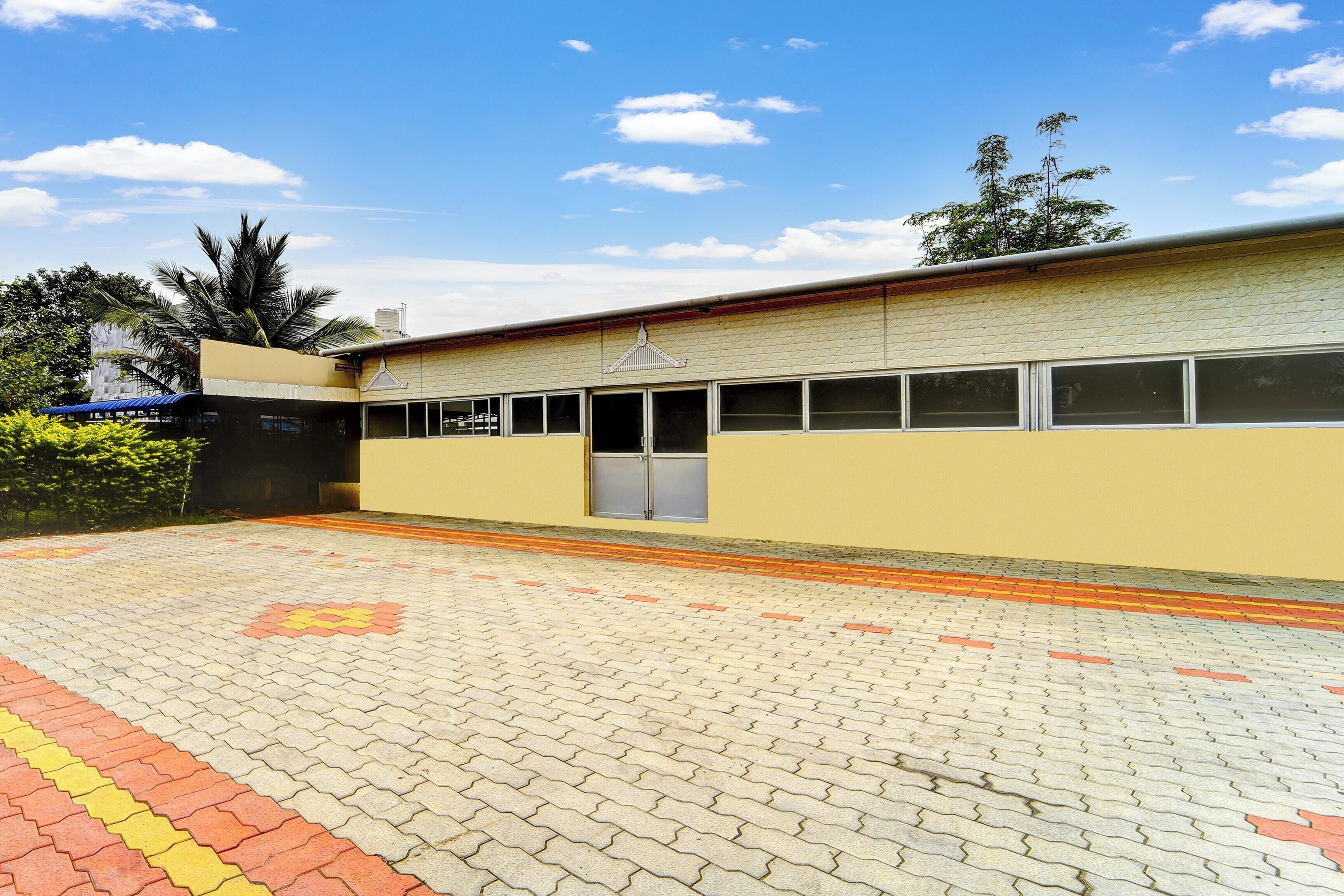 A building with a flat roof, large windows, and a paved entrance area.