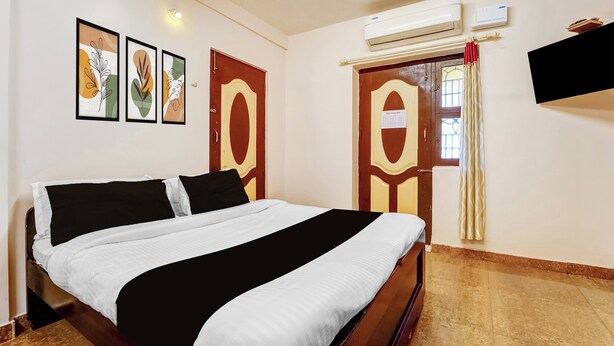 Een hotelkamer met een bed, een tv aan de muur en kunstwerken in lijsten.