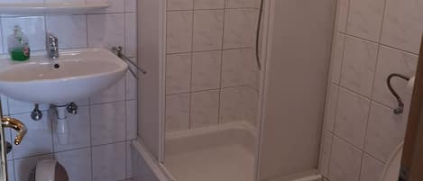 Ein Badezimmer mit Waschbecken, Toilette und Dusche.