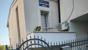 Un edificio con un letrero que dice 'APARTMANI GALIC' y una entrada con portón.