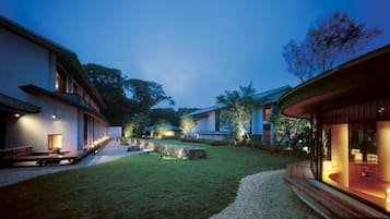 A residential property with a well-maintained lawn, a gravel pathway, and a wooden deck.