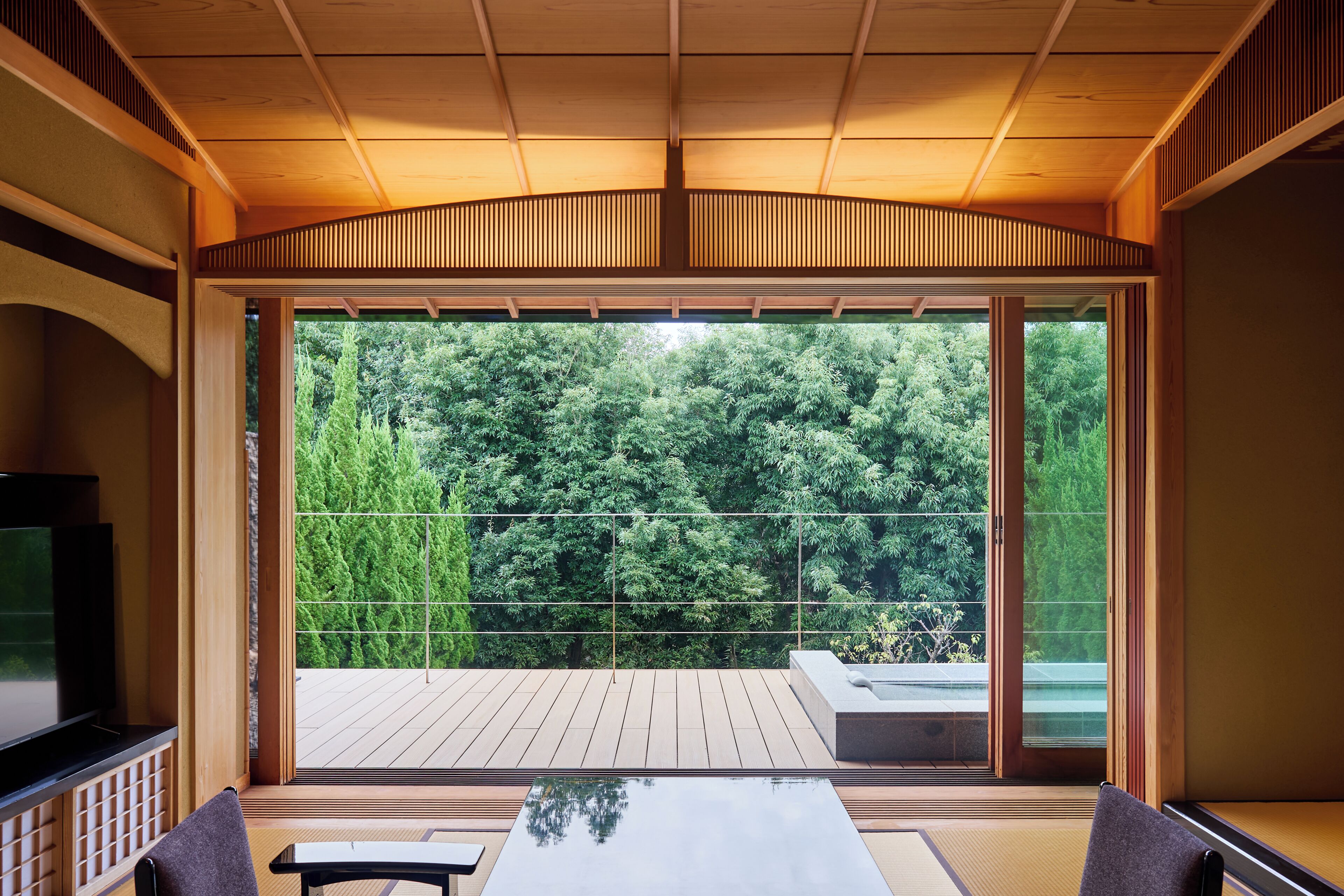 A modern interior with a large sliding glass door leading to a wooden deck.