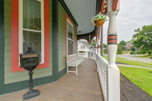 A porch with a white railing, a mailbox, and hanging flower baskets. - Aisling House - Historic Hospitality (Winchester)