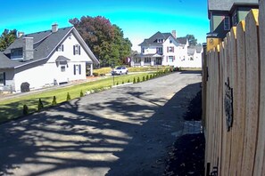 A residential street with houses, a white car parked on the side, and a wooden fence. - Aisling House - Historic Hospitality (Winchester)