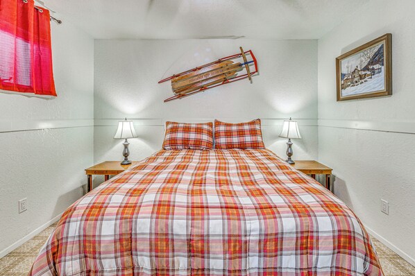 A bedroom with a plaid bedspread, two bedside lamps, a wooden ladder, and a framed picture on the wall. - Hike & Ski! Quiet Home w/ Solarium in Cloudcroft (Cloudcroft)