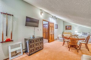 A cozy living room with a television, a billiards table, a wooden cabinet, and a dining area with chairs and a table. - Hike & Ski! Quiet Home w/ Solarium in Cloudcroft (Cloudcroft)