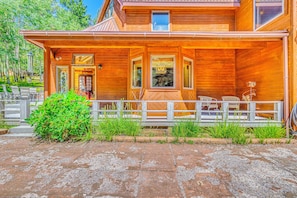 A wooden cabin with a covered porch, a stone pathway, and a small garden. - Hike & Ski! Quiet Home w/ Solarium in Cloudcroft (Cloudcroft)