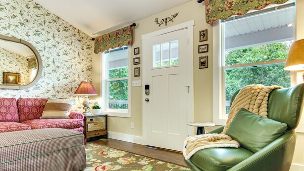 A room with a green leather chair, a patterned sofa, and a floral carpet. - Walk to Dtwn Waynesville! Dual Mtn Havens w/ Decks (Waynesville)