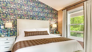 A neatly made bed with a patterned throw, a white headboard, and two bedside lamps. - Walk to Dtwn Waynesville! Dual Mtn Havens w/ Decks (Waynesville)