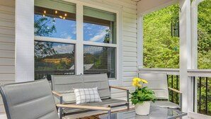 A covered porch with a seating area featuring a sofa and chairs, a glass table, and a potted plant. - Walk to Dtwn Waynesville! Dual Mtn Havens w/ Decks (Waynesville)