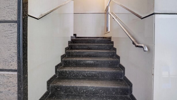 Una escalera con barandilla que sube.