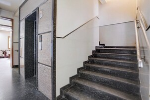 A staircase with a handrail and a door with a number display.