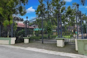 A gated area with a metal fence, concrete posts, and a street lamp.