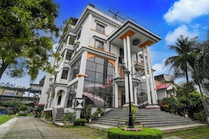 A multi-story building with a central staircase, large windows, and a balcony.