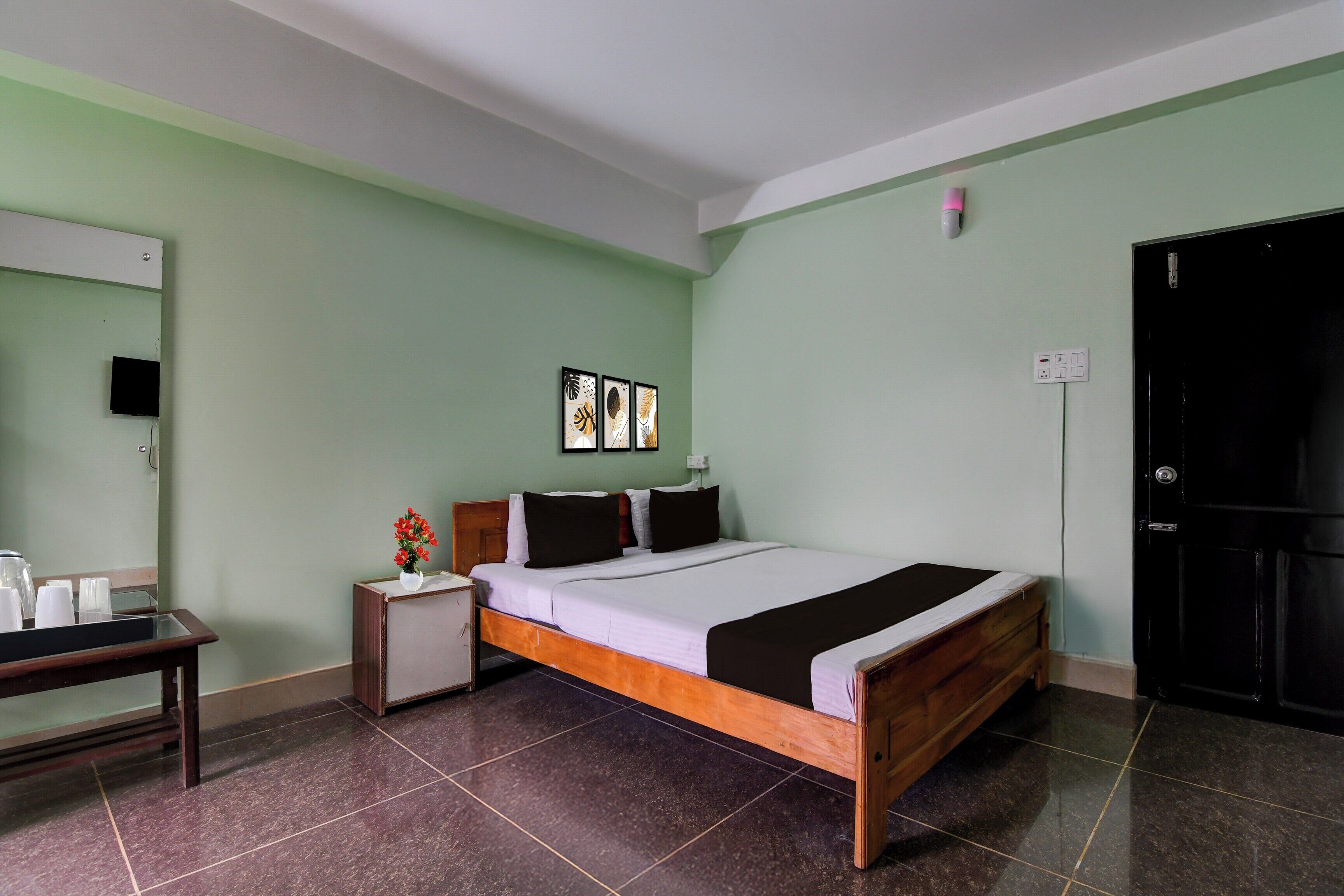 Quarto com cama, mesa de cabeceira e um pequeno armário.