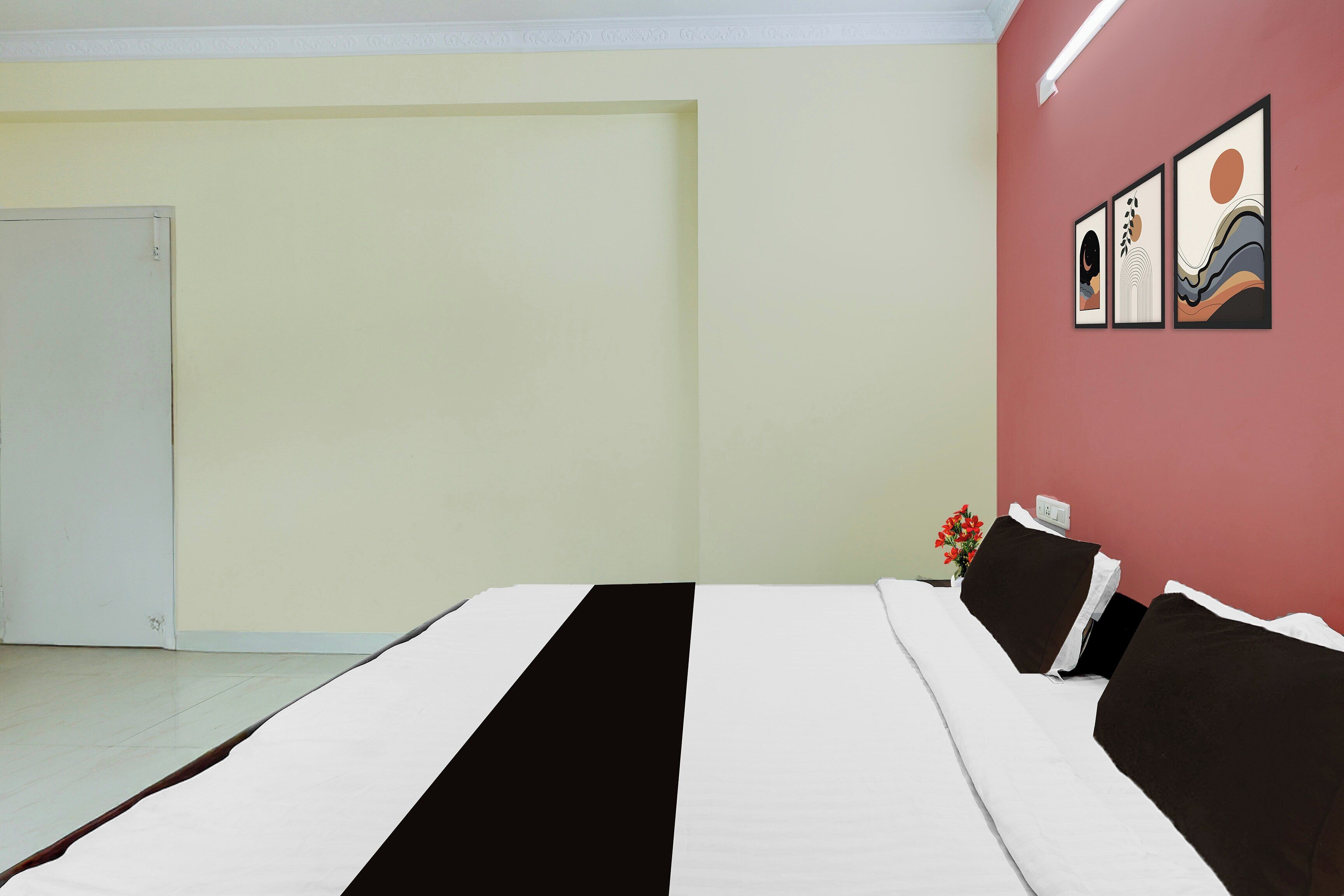Quarto com cama, uma porta e uma parede decorada com quadros.