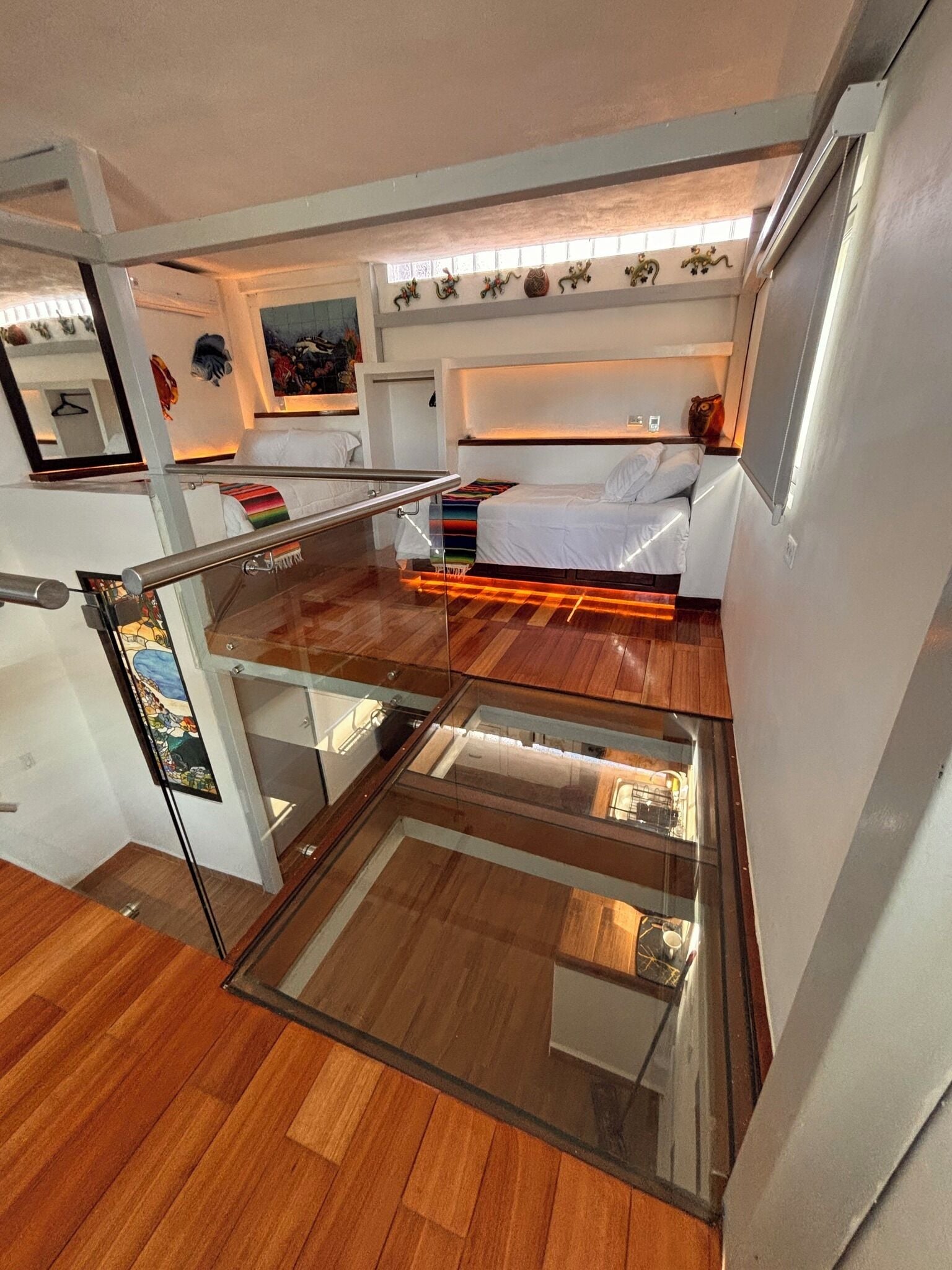 A compact room with a bed, a glass partition, and a small kitchen area.