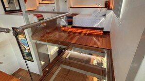 A compact room with a bed, a glass partition, and a small kitchen area. - Superb 6-bedroom Full House with AC in vibrant La Paz (La Paz)