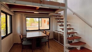 A room with a dining table, chairs, a staircase, and a window with a view. - Superb 6-bedroom Full House with AC in vibrant La Paz (La Paz)