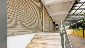 A staircase with a metal railing, leading to a covered area with a grid-like ceiling. - Super Collection O MG Road (Kanayannur)