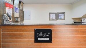 A reception desk with a sign indicating it is company-serviced. - Super Collection O MG Road (Kanayannur)