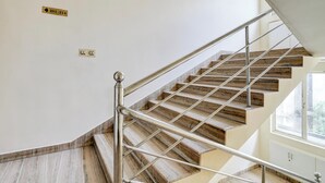 A staircase with a metal handrail and wooden steps, leading to an upper floor. - Super Collection O MG Road (Kanayannur)
