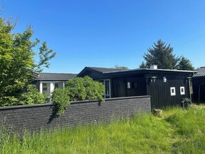 A residential area with houses, a stone wall, and a clear blue sky. - Panoramic sea view direct sandy beach Skagen South (Ålbæk)