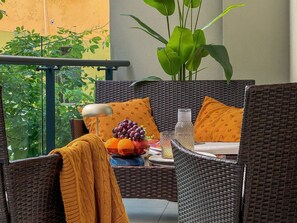 A wicker outdoor seating area with a table set for two, featuring a fruit bowl, a glass, and a candle. - Qoople Legend 36 В-04 100 Meter vom Strand entfernt by Interhome (Alanya)