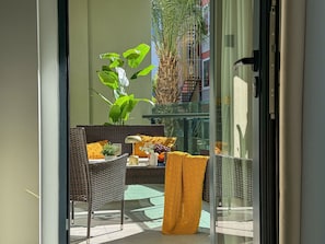 A balcony with wicker furniture, a potted plant, and a yellow throw blanket. - Qoople Legend 36 В-01 100 Meter vom Strand entfernt by Interhome (Alanya)