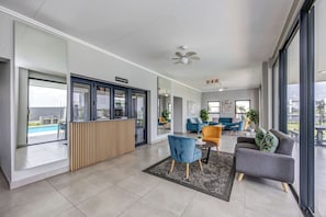 Een modern interieur met een koffiebar, een zithoek met banken en stoelen, en grote ramen met uitzicht.