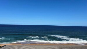 Udsigt til havet fra en balkon med klar himmel.