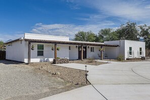 A two-story building with a white exterior, a covered porch, and a gravel driveway. - 7 Mi to Saguaro Nat’l Park! Mtn-View Haven w/ Pool (Tucson)