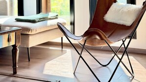 A modern room with a leather chair, a small table, and large windows. - Kenz Essia Luxury countryside escape near Tunis (Chaouat)